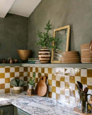 Kuchyně ve středomořském stylu s texturovanou olivovou barvou a glazovaným šachovnicovým pozadím